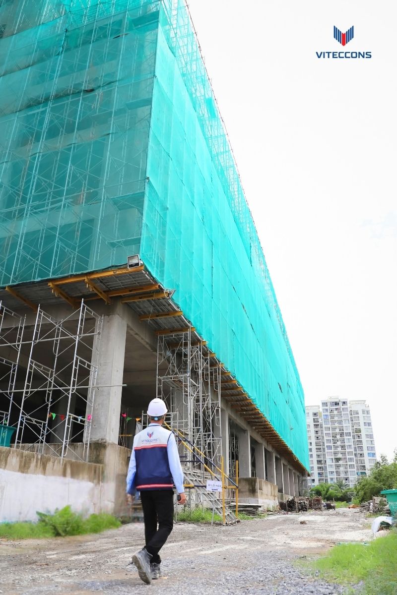 Anh Văn Anh đi về phía công trình đang thi công