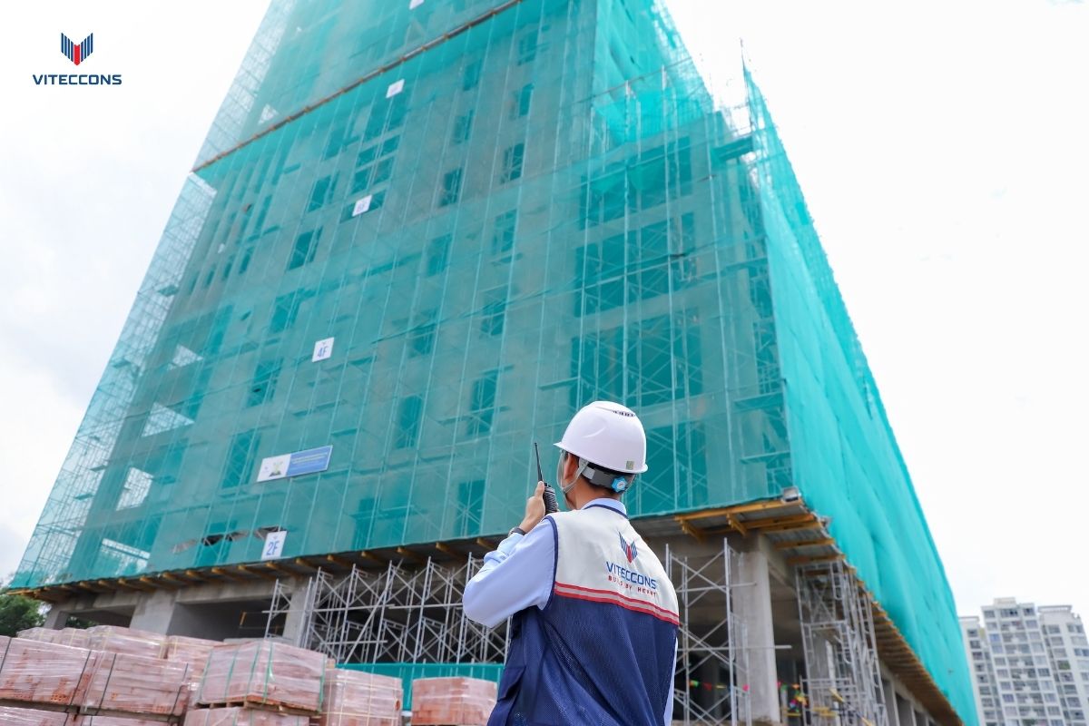 Anh Văn Anh cầm bộ đàm quan sát công trình đang thi công
